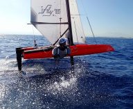 iFLY15 foiling catamaran in Ferrari Red – high-tech hydrofoil sailboat designed for easy access into foiling, precision, and peak performance, inspired by SailGP technology.