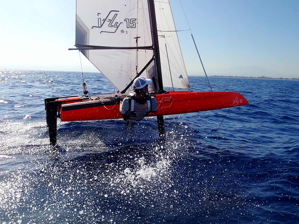 iFLY15 foiling catamaran in Ferrari Red – high-tech hydrofoil sailboat designed for easy access into foiling, precision, and peak performance, inspired by SailGP technology.